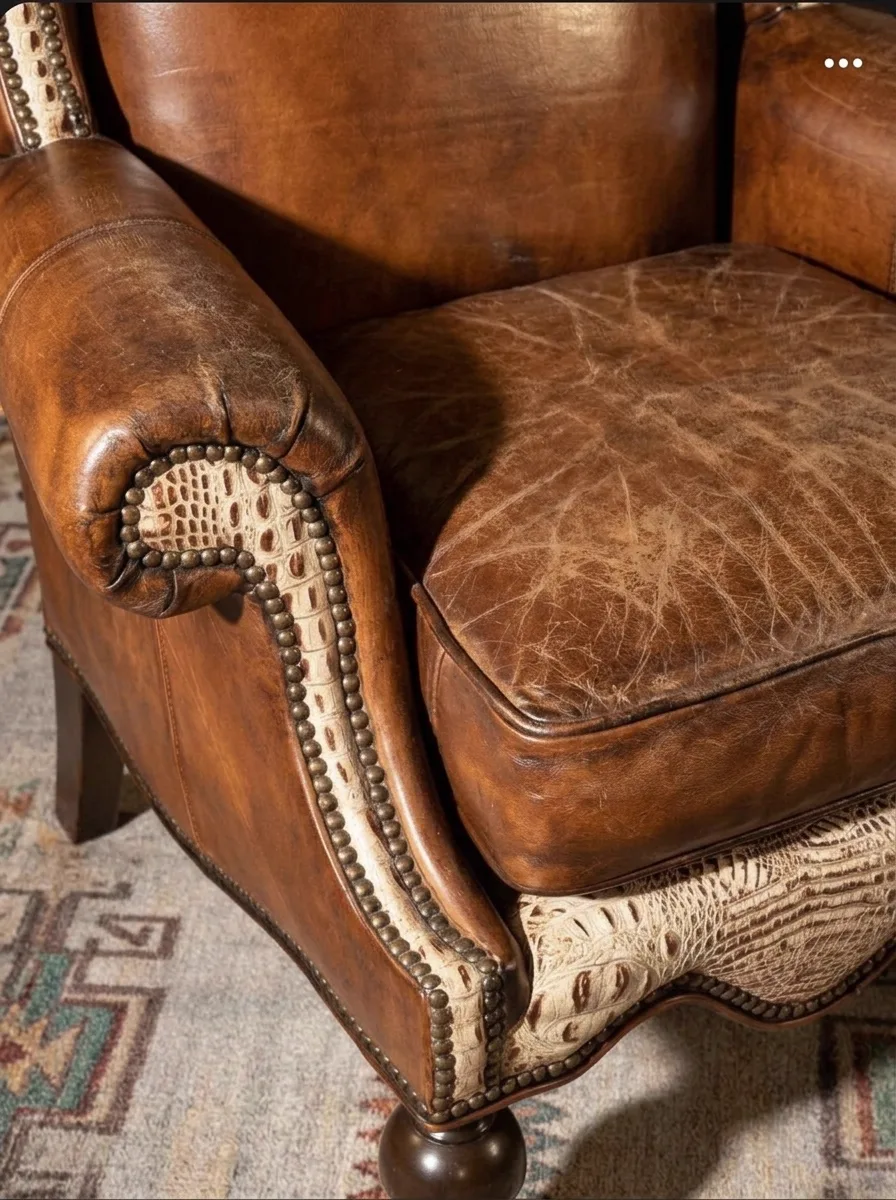 Faded, dry whisky-tan leather wingback club chair before restoration